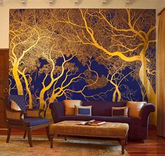 a living room with a couch, chair and tree mural on the wall behind it