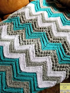 a crocheted blanket sitting on top of a couch