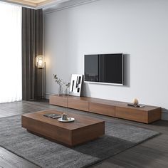 a living room with a large television on the wall next to a couch and coffee table