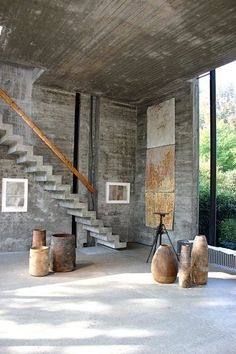 an empty room with stairs and vases on the floor