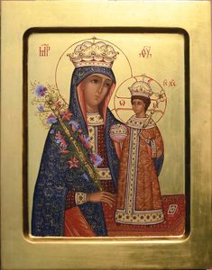 an icon of the mother and child with flowers in her hand, on a gold frame