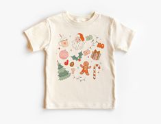 Retro Christmas Doodles Kids Shirt - Favorite Holiday Things Santa, Candy Canes, Trees Family Outfit - Boho Natural Toddler & Youth Tee If you love super soft, lightweight, extremely comfy shirts and baby bodysuits then you will absolutely love our unisex kids shirts and baby bodysuits! These shirts are hand printed with a professional garment printer for a soft, durable, long lasting, printed graphic using high quality water based inks. * The printed design is very soft to the touch due to our printing process blending the eco-friendly ink directly into the garment. * Shirt and design colors may vary slightly due to monitor and lighting. * This is a Unisex style tee kids tee, please see our sizing charts in the images for a look at either toddler, youth and baby sizes in detail. * Solid C Holidays With Toddlers, Outfit Boho, Kids Doodles, Santa Candy, Retro Santa, Christmas Doodles, Comfy Shirts, Candy Canes, Holiday Shirts