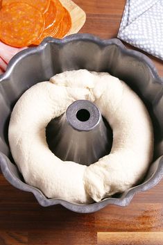 a bundt pan with dough in it on a wooden table next to other ingredients