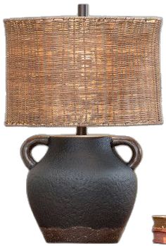 a table lamp with a brown shade on it and a small vase next to it