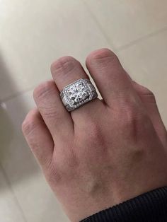 a man's hand with a diamond ring on it