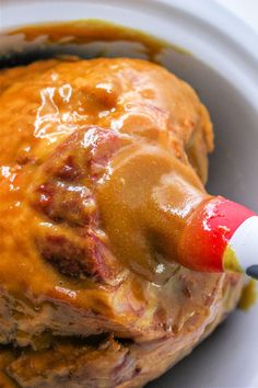 a piece of meat covered in gravy with a toothpick sticking out of it