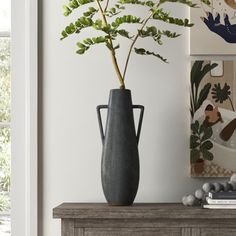 a vase with a plant in it sitting on a table