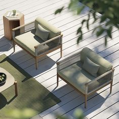 three chairs and a coffee table on a wooden deck with green cushions, pillows and rugs