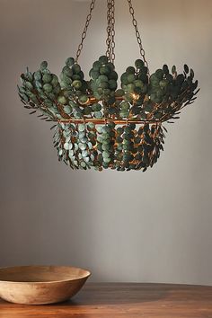 a bowl sitting on top of a wooden table next to a light fixture hanging from the ceiling