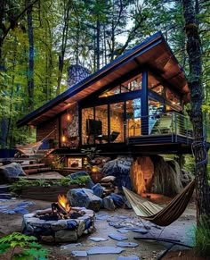 a house in the woods with a hammock hanging from it's roof