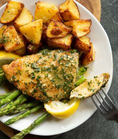 a white plate topped with chicken, potatoes and asparagus next to a fork