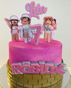 a pink cake with three people on top and the words peppux spelled in large letters