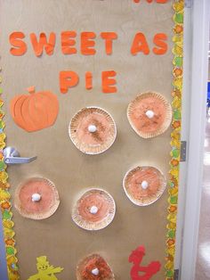 a door decorated with paper plates and pumpkins for sweet as pie, on display