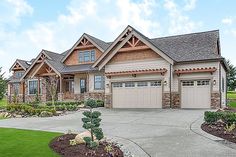 a large house with two garages and landscaping around it on a nice, sunny day