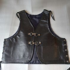 Leather vest, biker cowl, for children aged 8 and over -Germany size 122/128 -USA size 7 - 8 -genuine leather -black -dark blue polyester lining -Shoulder and side lacing with eyelets -2 small pockets -Carabiner clasp Dimensions in cm / ", as in the last photo, measured at the back: A: Width over the shoulder 25 cm/ 9.8" B: Bottom width 40 cm/ 15.7" C: Length from shoulder 40 cm/ 15.7" D: Length of side lacing 15 cm/ 6" E: Length shoulder lacing 5 cm/ 2" These costumes for children are popular with bikers. I sew the parts from one piece of leather, without any intermediate seams. The fit has proven itself. For this cowl I used a stronger cowhide. This vest has already been finished by me and is therefore ready for shipping. You can find other sizes in my shop. In my shop you will find othe Biker Leather Vest, Waistcoat Pattern, Leather Waistcoat, Black Leather Vest, Kids Vest, Biker Leather, Vest Outfits, Leather Vest, Dark Black