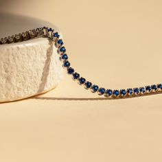 Make a shimmering statement with our Blue Sapphire Diamond Tennis Bracelet. Elegant and dainty, it adds the perfect bold, finishing touch to your outfit for special occasions like anniversaries or weddings. A minimalist accessory sure to shine and a dazzling symbol of “something blue” for brides. Material: High Quality Solid 925 Sterling Silver Finish: Sterling Silver ∙ 18K Gold Clasp: Box clasp and side prong closure Featuring a 6 inch (ONE SIZE) ~3mm Tennis Bracelet with half CZ Sapphire and h Timeless Blue Round Bracelets, Timeless Blue Bracelet For Formal Occasions, Formal Sapphire Round Bracelets, Timeless Blue Diamond Bracelet, Formal Round Sapphire Bracelet, Classic Sapphire Bracelet With Prong Setting, Sapphire Bracelets With Prong Setting For Anniversary, Sapphire Tennis Bracelet Fine Jewelry With Prong Setting, Classic Sapphire Tennis Bracelet With Prong Setting