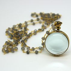 Brass and silver locket chains are available in labradorite, freshwater pearls,14kt gold-filled, and sterling silver. The glass is encased in brass or sterling silver. The round pendant is 25 mm in diameter; the square pendant is 23 mm across Available in lengths 26 and 34 inches (Note: the labradorite and pearl chains do not have a clasp, they slip right over the head - if you would like one just let me know and I'll put one on at no extra cost) Starting at $123.99 The glass locket necklace has Spiritual Round Glass Pendant Jewelry, Spiritual Glass Jewelry With Round Pendant, Elegant Glass Pendant Necklace, Spiritual Glass Pendant Jewelry, Elegant Round Glass Crystal Necklaces, Memorial Amulet Locket Necklace, Elegant Glass Pendant Jewelry, Elegant Labradorite Necklace With Adjustable Chain, Antique Glass Jewelry As Gift