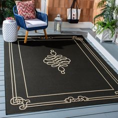 a black area rug with gold trimmings and a blue chair in front of a fireplace