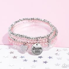 Reflective pink, defaced silver, reflective white, and smooth silver beads wrap around stretchy bands, and combine into a colorful stack along the wrist. The reflective, pink-beaded bracelet features a silver pendant with the phrase "dream BIG" stamped on it, while a defaced, silver-beaded bracelet features a silver star charm. Hanging from smooth, silver beads, a heart charm embossed with iridescent rhinestones adds a shimmery detail to the stack, resulting in a youthful, dreamy design. Due to Pink Beaded Bracelets, Pink Charm, Blue Beaded Bracelets, Snap Bracelets, Wooden Bracelet, Inspirational Bracelets, Beaded Wraps, Paparazzi Accessories, Seed Bead Necklace