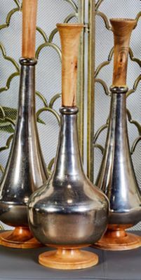 three silver vases sitting on top of each other next to a wooden spoon and knife