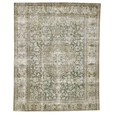 an antique rug with green and beige colors