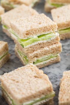 several sandwiches stacked on top of each other with cucumber in between the sandwiches