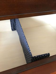 a blue tie laying on top of a wooden table