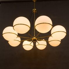 a chandelier hanging from the ceiling in a room with black walls and flooring