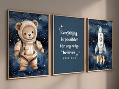 three wall hangings with an image of a teddy bear and a rocket ship on them