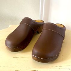 Previously Owned Never Worn. Size 39 Classic Closed Toe Clogs With Cushioned Footbed, Classic Clogs With Wooden Heel And Round Toe, Brown Closed Toe Mules With Cushioned Footbed, Classic Brown Slip-on Clogs, Spring Clogs With Round Toe In Brown, Brown Clogs With Rubber Sole And Round Toe, Brown Closed Toe Clogs With Removable Insole, Brown Clogs With Rubber Sole, Comfortable Brown Clogs With Rubber Sole