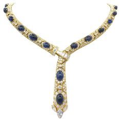 The intricate detail featured in the creation of this Diamond Sapphire Adjustable Necklace is just one of its many striking attributes. There are 25cts of sparkling white diamonds set into the stylish framework of 18k yellow gold. A cabochon cut highlights the beautiful color of 30cts of sapphires, that adorn all 17 inches of this jeweled neck piece. A 1.02ct marquee cut diamond, GIA certified D color, sparkles at the bottom. An 18k gold clasp, inlaid with white diamond baguettes, makes the necklace adjustable for various looks. Stunning! 53.8DW Luxury Diamond Cabochons For Wedding, Luxury Diamond Cabochons For Formal Occasions, Exquisite Formal Gemstone Cabochons, Formal Hallmarked Diamond Cabochons, Luxury Yellow Gold Gemstone Cabochon, Fine Jewelry Yellow Gold Cabochons For Formal Occasions, Luxury Gold Diamond Cabochons, Luxury Sapphire Gemstone Diamond Necklace, Elegant Cabochon Sapphire Jewelry