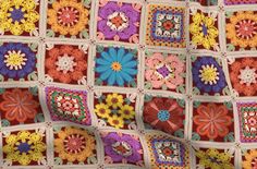 a crocheted blanket with many different colors and designs on the front, including flowers