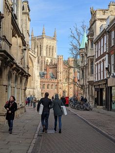 two people walking down the street in front of some buildings