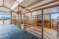 the inside of a horse barn with lots of wood and metal in it's stalls