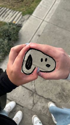 someone is holding up a sticker with a smiley face on it's fingers