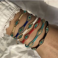 a woman's arm with four different bracelets on top of each other,