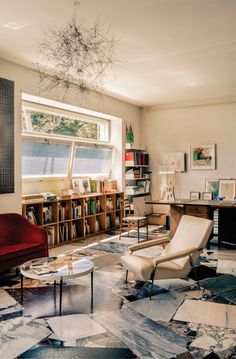 a living room filled with lots of furniture and bookshelves next to a window