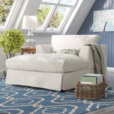 a white chaise lounger sitting on top of a blue rug in a living room