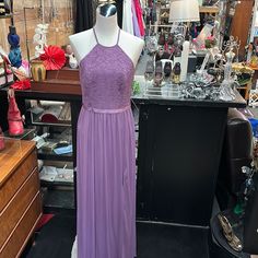 a purple dress is on display in a store with other items and accessories behind it