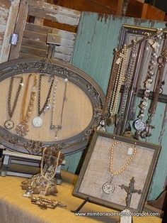 an assortment of necklaces and watches on display in front of a wooden wall with old doors