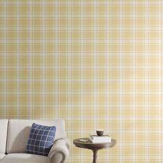 a couch and table in front of a yellow plaid wall