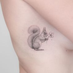 a woman's breast with a squirrel tattoo on it