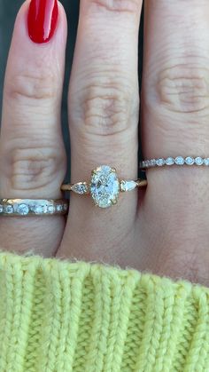 a woman's hand with three different rings on it