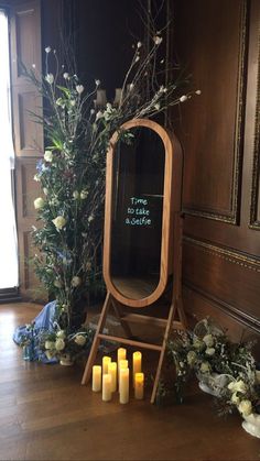 a mirror sitting on top of a wooden floor next to candles