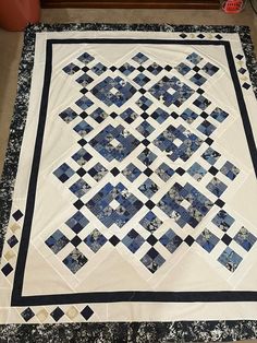 a blue and white quilt is laying on the floor