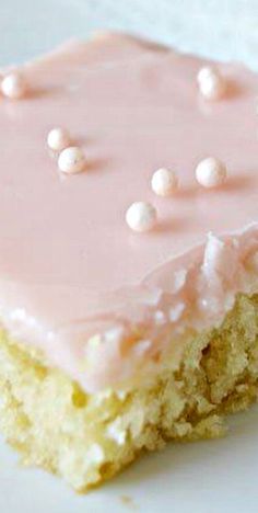 a piece of cake with pink frosting and white sprinkles on it