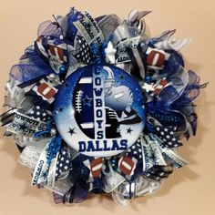 a wreath with the word cowboys on it and footballs in blue, white and silver