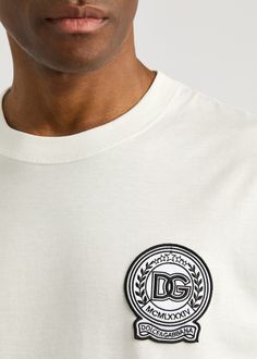 Find DOLCE & GABBANA Logo-appliquéd Cotton T-shirt on Editorialist. Info & Care Dolce & Gabbana cotton T-shirt; Ribbed crew-neck, dropped shoulders, logo-embroidered patch appliqué at chest Slips on 100% cotton; Machine wash; Size & Fit Length shoulder to hem: 29.5 inches/ 75cm; Midweight; Relaxed fit; Model is 6'3'/ 191cm, chest size 38 inches and wears a size medium Cotton Graphic Tee With Appliqué Logo, Designer Cotton T-shirt With Embroidered Logo, White Short Sleeve Top With Logo Patch, White Cotton T-shirt With Appliqué Logo, Cotton Crew Neck Top With Embroidered Patch, White Cotton Tops With Logo Patch, Cotton Graphic Tee With Logo Patch, White Crew Neck T-shirt With Logo Patch, Crew Neck Tops With Embroidered Patch For Streetwear