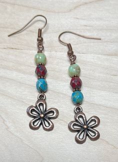 Boho style earrings with rustic vibes!  These were created using Czech Picasso glass beads in sage, sky blue, and dark maroon red.  I have also used copper spacer beads, and antique copper flower charms.  Great casual, everyday earrings! Total length of earrings, including the ear wire, is slightly over 2-1/4".   Matching necklace: https://www.etsy.com/listing/1601876489/rustic-beaded-czech-glass-necklace-with?click_key=a3e58bfd6a6adb1fee441eac4debfa990bed2937%3A1601876489&click_sum=6da8d6b9&ref=shop_home_active_1&frs=1 Matching bracelet: https://www.etsy.com/listing/1587641712/rustic-handmade-beaded-boho-bracelet?click_key=87b993c1a0be3c27bded97932f9f89f3cd6d558c%3A1587641712&click_sum=79f10a43&ref=shop_home_active_1&frs=1 Thank you for shopping with The Lucie Collection! Multicolor Bohemian Earrings With Flower Charm, Bohemian Multicolor Earrings With Flower Charm, Adjustable Bohemian Flower Earrings, Adjustable Bohemian Drop Flower Earrings, Bohemian Brown Dangle Flower Earrings, Bohemian Czech Glass Dangle Flower Earrings, Brown Bohemian Drop Flower Earrings, Bohemian Flower-shaped Metal Earrings, Bohemian Brown Flower Earrings