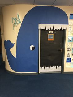 a blue whale painted on the side of a wall next to a door with an open window